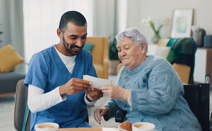 Elderly female patient sharing photos with male nurse